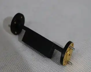 What are the fundamental differences between waveguide fixed attenuators and coaxial fixed attenuators?